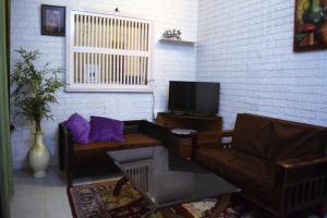 a living room with a couch and a tv at Men-only COZYCORNER in Lucknow