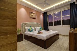 Infinity Luxury Villa - 5BHK | Pool | Baga Beach | DanCenter في آربورا: غرفة نوم بها سرير في غرفة بها نوافذ