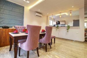 Infinity Luxury Villa - 5BHK | Pool | Baga Beach | DanCenter في آربورا: غرفة مع طاولة وكراسي و سبورة