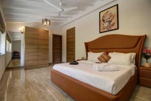 Infinity Luxury Villa - 5BHK | Pool | Baga Beach | DanCenter في آربورا: غرفة نوم بها سرير كبير في الغرفة