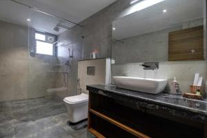 Infinity Luxury Villa - 5BHK | Pool | Baga Beach | DanCenter في آربورا: حمام مع حوض ومرحاض