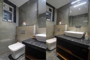 Infinity Luxury Villa - 5BHK | Pool | Baga Beach | DanCenter في آربورا: حمام مغسلتين ومرحاض ومرآة