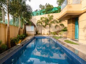 een zwembad voor een gebouw met bomen bij Villa Aumentar by DanCenter in Arpora