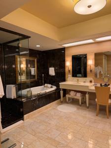 ein großes Badezimmer mit Badewanne und Waschbecken in der Unterkunft 澳门高奢酒店套房特价一折起预定 in Macau