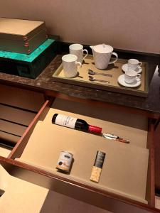 ein Regal mit einem Tisch, auf dem eine Flasche Wein und Tassen stehen. in der Unterkunft 澳门高奢酒店套房特价一折起预定 in Macau + 50 Fotos