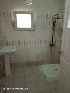 Jeng's paradaise green house في Sukuta: حمام مع حوض ودش ومرحاض