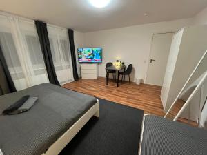 a bedroom with a bed and a table and a television at FlexStay Room 9 in Karlsruhe