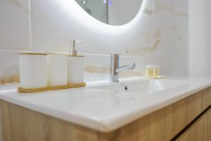 a bathroom with a white sink and a mirror at Coração de Viana AL in Viana do Castelo