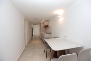 埃拉特Sea Side Luxury- סי סייד的厨房和餐厅配有白色桌子和椅子 更多68张照片