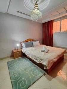 ein Schlafzimmer mit einem großen Bett mit einem grünen Teppich in der Unterkunft blue wave residense tamraght in Tamraght Ou Fella