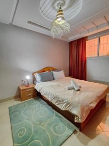ein Schlafzimmer mit einem großen Bett und einem Kronleuchter in der Unterkunft blue wave residense tamraght in Tamraght Ou Fella + 14 Fotos