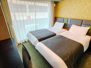 那霸APA Hotel Naha Airport Wakasa的带窗户的酒店房间里有两张床 更多37张照片