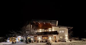 a large house at night in the snow at Haus Galgenul by A-Appartments in Galgenul