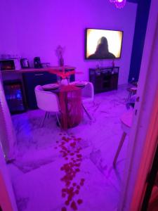een kamer met een paarse kamer met een tafel en stoelen bij Love Room romantique avec jacuzzi - Arles centre in Arles +18 foto's