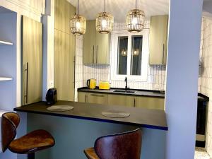 Charming Acropolis Flat with stunning Roof Terrace في أثينا: مطبخ مع كونتر وكراسي وأضواء +31 صورة