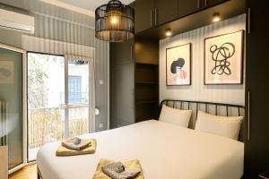 Charming Acropolis Flat with stunning Roof Terrace في أثينا: غرفة نوم بسرير أبيض ونافذة