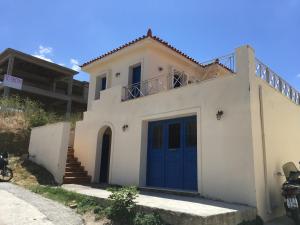 a white house with a blue door at Theo's house in Chora! in Andros