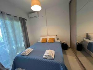 ein Schlafzimmer mit einem blauen Bett mit Handtüchern darauf in der Unterkunft Eftyhia's Cozy apartment Patmos in Skala