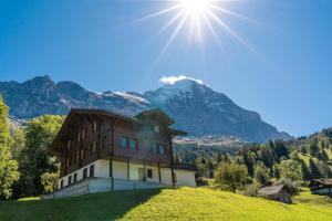 a house on a hill with a mountain in the background at Chalet Studen in Grindelwald