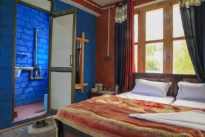 列城Eco Friendly Guest House的一间卧室，有两张床和一面蓝色的墙