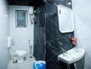 un bagno con un water bianco e un lavandino di Twilight Stays ll R Villa 3BHK ll Swimming Pool ll AC ll BBQ a Lonavala Altre 10 foto