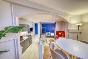 een keuken en eetkamer met een witte tafel en stoelen bij La porte de Mars - Air conditioning in Reims