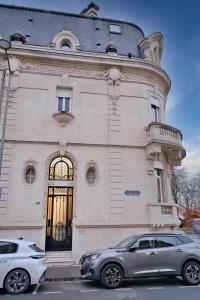 twee auto's geparkeerd voor een gebouw bij La porte de Mars - Air conditioning in Reims