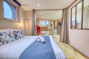 een slaapkamer met een bed en een groot raam bij La porte de Mars - Air conditioning in Reims