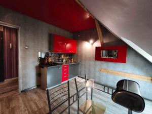 una piccola cucina con armadi rossi e bancone di Apartament Gościnne Gniazdo a Gliwice