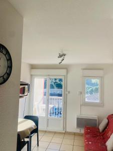 ein Wohnzimmer mit einem roten Sofa und einem Fenster in der Unterkunft Appartement in Lamalou-les-Bains