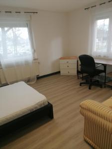 Un dormitorio con una cama, un escritorio y una silla. en Strasbourg Pont de l'Europe, en Kehl am Rhein