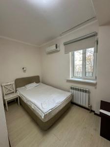 (( Turksib ))Алматы Транзит №1的一间卧室，有一张白色的床和一扇窗户