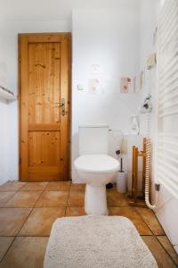 ein Badezimmer mit Toilette und Holztür in der Unterkunft Tatralandia - Apartmán ZOJA in Liptovský Mikuláš