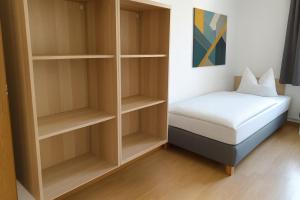 メルゼブルクにあるMonteurwohnung Merseburgのベッドと本棚のある小さな寝室