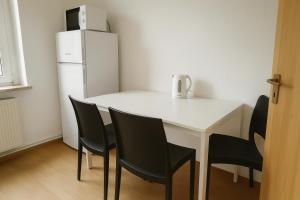 メルゼブルクにあるMonteurwohnung Merseburgのキッチン(白いテーブル、椅子、冷蔵庫付)
