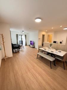 Una gran sala de estar con mesa y sillas. en 福の荘 空港3号棟, en Wada