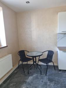 a dining room with a table and two chairs at stary PGR rooms & hostel in Grabik +3 photos