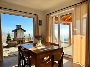 una sala da pranzo con un tavolo e una grande finestra di Domek na Wielkiej Górze a Waksmund