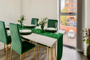 a dining room with a green table and chairs at Cinema Lounge 2Bed Leeds City Centre FREE Parking in Leeds +15 photos