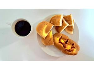 a plate of food with buns and a cup of coffee at Grampus Inn Osaka Namba in Osaka