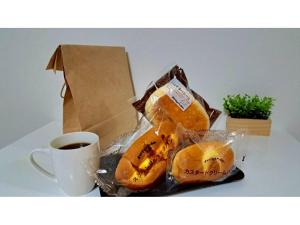 a bag of bread sitting next to a cup of coffee at Grampus Inn Osaka Namba in Osaka