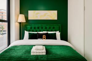 a green bedroom with a bed with a green headboard at Cinema Lounge 2Bed Leeds City Centre FREE Parking in Leeds
