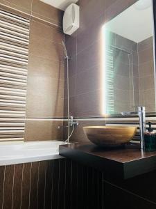 a bathroom with a sink and a mirror and a tub at Zilina Sweet Escape in Žilina +19 photos
