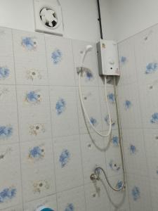 a shower in a bathroom with blue flowers on the wall at A Nature House in Ko Lanta Yai