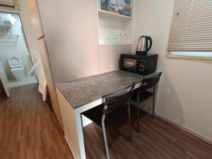 a kitchen with a counter with two chairs and a microwave at Affordable Private Studio Al Reem Island in Abu Dhabi +1 photo