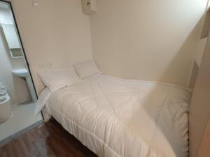 a white bed in a small room with a window at Affordable Private Studio Al Reem Island in Abu Dhabi