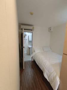 a bedroom with a white bed and a bathroom at Affordable Private Studio Al Reem Island in Abu Dhabi