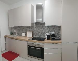 a kitchen with white cabinets and a counter top at I Giardini Magenta in Magenta