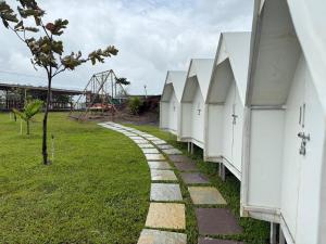 a row of white buildings next to a park at Pawna Lake Camping Bramhnoli in Lonavala