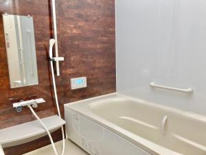 隠れ宿 藤 Private Inn Fuji - 足利駅5分の一棟貸切のお宿 في أشيكاغا: حمام مع حوض استحمام بجوار حوض +4 صور